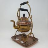 An Arts an Crafts copper and brass kettle on stand, 39 cm high