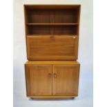 An Ercol light elm cabinet, with open shelf above fall front to reveal a fitted interior on a base