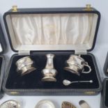 A silver three piece cruet, boxed, an egg cup and spoon, boxed, a napkin ring, boxed, a glass