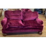 A red velvet three piece suite, a comprising sofa, and two armchairs, on large oak bun feet (3) Sofa