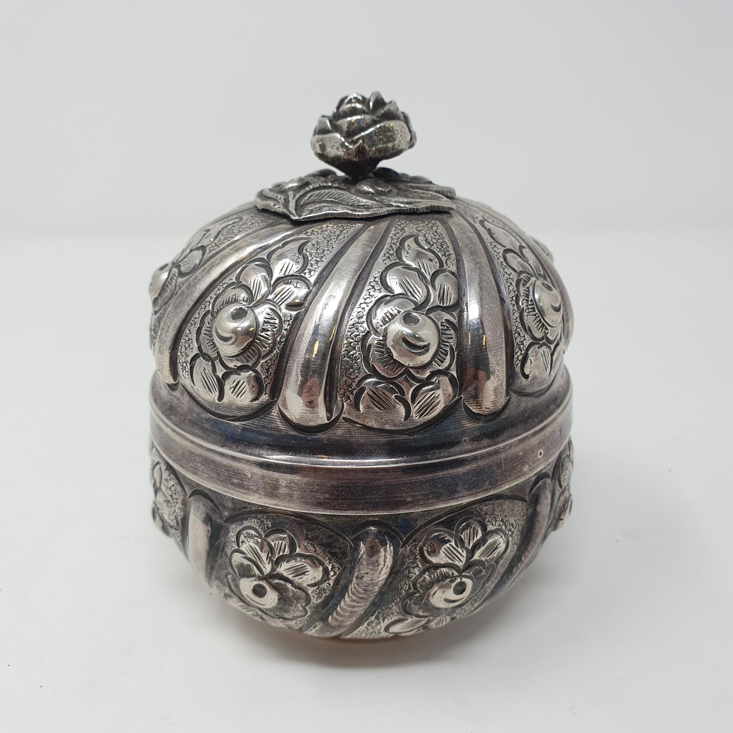 A Continental silver colour metal box, decorated flowers, 9 cm diameter 6.9 ozt, untested