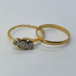 An 18ct gold three stone diamond ring, ring size R, and a wedding band (2) Wedding band bent,