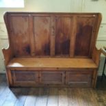 A 19th century pine settle, the base with two cupboard doors, 152 cm high x 184 cm wide