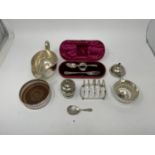 A silver coaster, sugar bowl, pepper pot, toast rack, caddy spoon, fork, spoon, and a napkin ring,