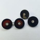 A pair of black onyx and diamond cufflinks