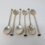 A set of six silver coloured metal coffee spoons, the finials inset with amethyst, stamped 990 and