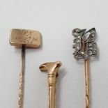 A stick pin, initialed B with diamonds, a 9 ct gold riding crop stick pin and another stick pin, the