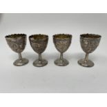 A set of four Chinese silver coloured metal egg cups, decorated dragons, 6.5 cm high (4) Slight