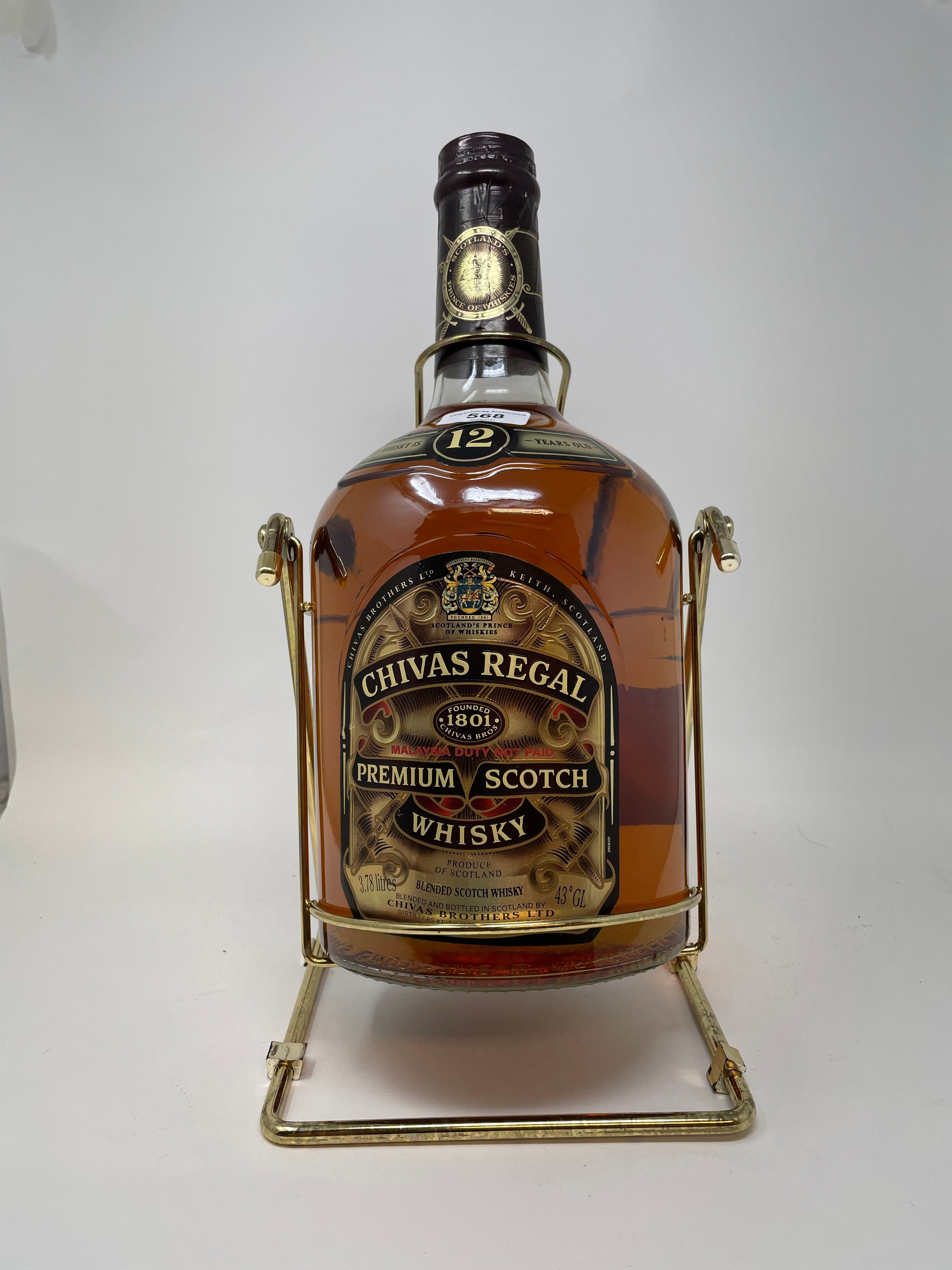 A 3.78 litre bottle of Chivas Regal whisky, in a metal cradle, with cardboard box