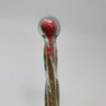 A late 19th/early 20th century glass walking cane, filled with various coloured beads, 118 cm long