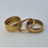 An 18ct gold wedding band, 6.1 g and two 9ct gold wedding bands, 7.7 g
