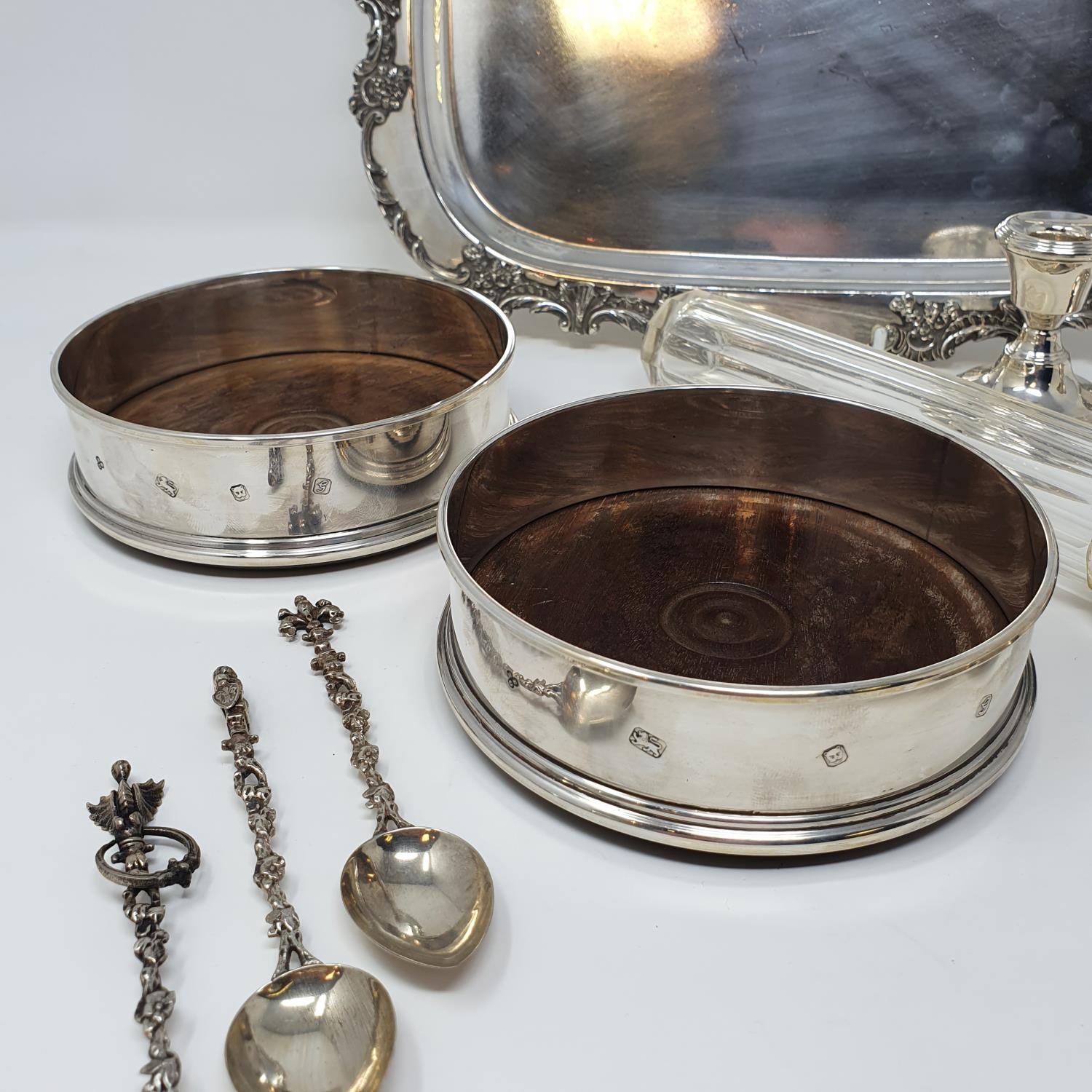 A pair of silver bottle coasters, with turned wooden bases, London 1981, 12.5 cm diameter, set of