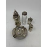 A George V silver ashtray, a sifter, two pepper pots, 10.2 ozt, and a silver topped bottle (5)