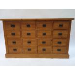 A modern pine apothecary style chest, having 16 drawers, 138 cm wide