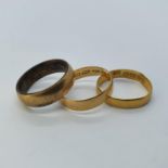 A 22ct gold wedding band 2.1 g, an 18ct gold wedding band 1.5 g and a gilt metal wedding band (3)