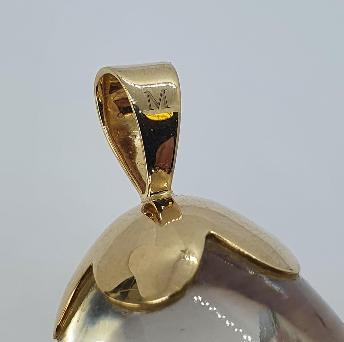 A pear shaped rock crystal pendant, with a yellow coloured metal suspension, 5.5 cm high Flawed/ - Image 2 of 2