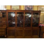 A George III style mahogany breakfront bookcase, the top with four glazed doors on a base with