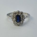 An 18ct white gold, oval sapphire and diamond cluster ring, ring size M Sapphire weight 0.75ct