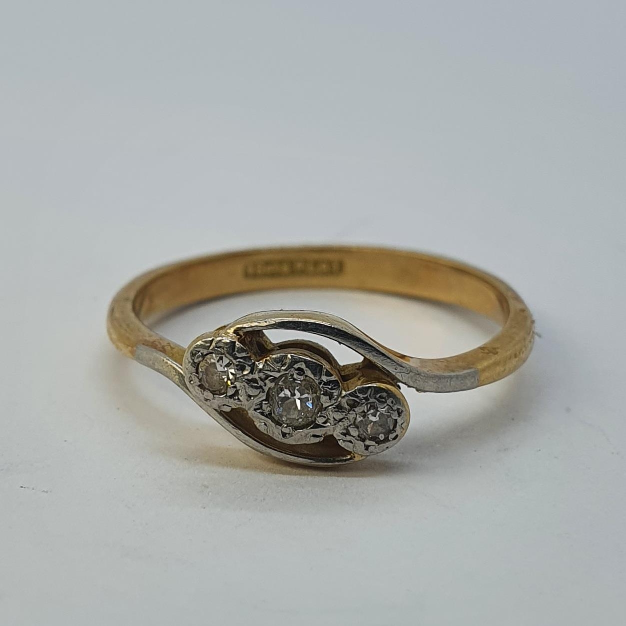 An 18ct gold and three stone diamond ring, ring size N All in 2.9g