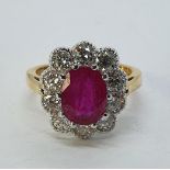 An 18ct gold, ruby and diamond cluster ring, ring size M Oval cut ruby 2.50ct approx. Diamonds 1.