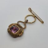A 19th century yellow coloured metal seal fob, inset with a purple and white stone All in weight
