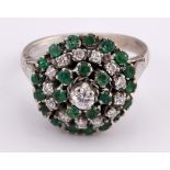 An 18ct white gold, emerald and diamond cluster ring, ring size N 1/2
