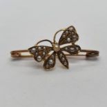 A late 19th/ early 20th century yellow coloured metal and seed pearl stick pin, in the form of a
