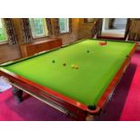 A full size mahogany snooker table, on reeded and lobed legs, with a cover, balls, cues, score