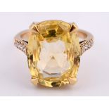 A yellow coloured metal ring, set a 13.56ct rectangular cushion natural yellow sapphire, with 10