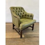 A green leather button back armchair, on mahogany legs