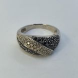 A 14ct white gold, diamond and black diamond ring, ring size R