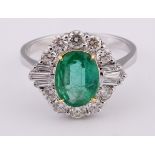 An 18ct white gold, oval cut emerald and diamond cluster ring, ring size M Emerald weight 1.41ct