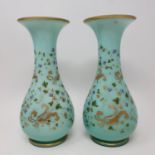 A pair of early 20th century green glass vases, highlighted in gilt, 24 cm high, three cups and