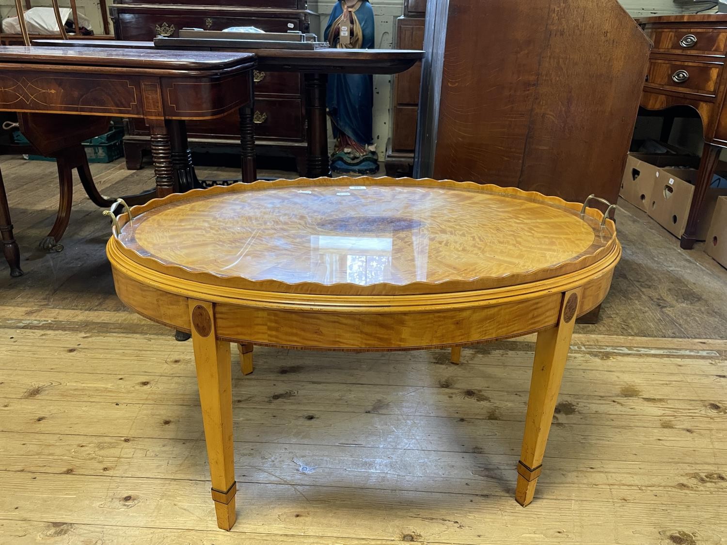 A modern satinwood oval tray top table, on square tapering legs, 98 cm diameter