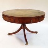 A George III style mahogany drum top table, the leather inset top above four real and four false