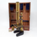 An early 20th century brass students microscope in a mahogany case