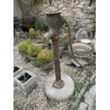 A cast metal water pump, by S Owens & Co Engineers London, on a composite stone round base, 139 cm