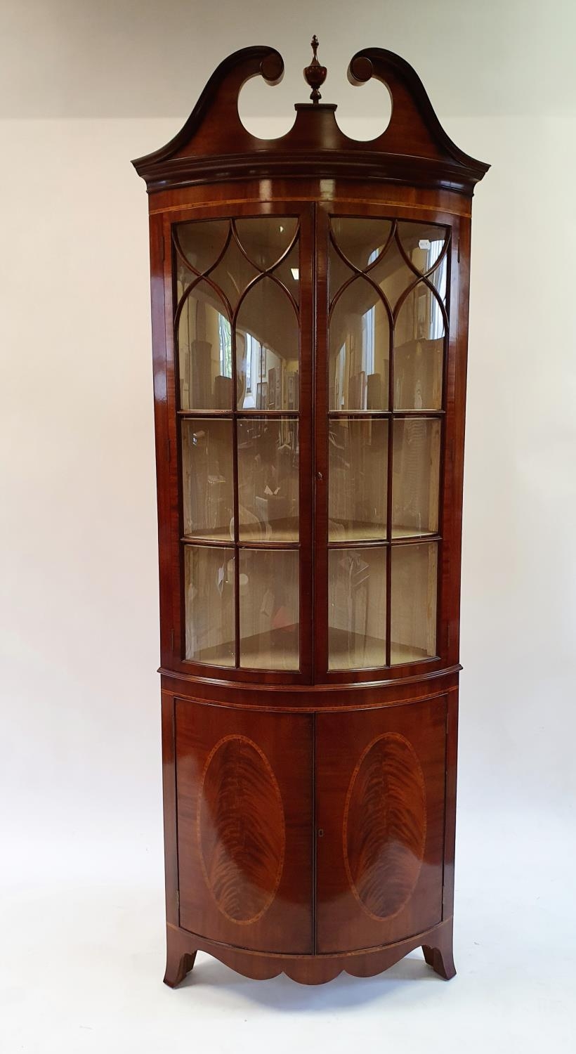 A George III style mahogany bow front free standing corner cupboard, with two glazed doors, above