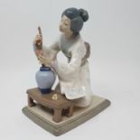 A Lladro figure, of a Japanese lady tending to a flower, 21 cm high, boxed Possible but very small