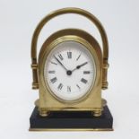 A mantel clock, with oval enamel dial, with Roman numerals, in brass case, 15 cm high