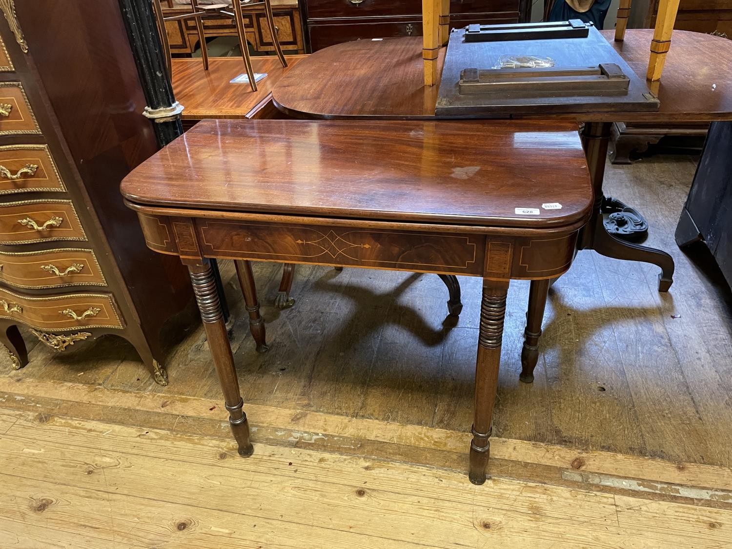 A 19th century mahogany folding tea table, on turned tapering legs, 91 cm wide