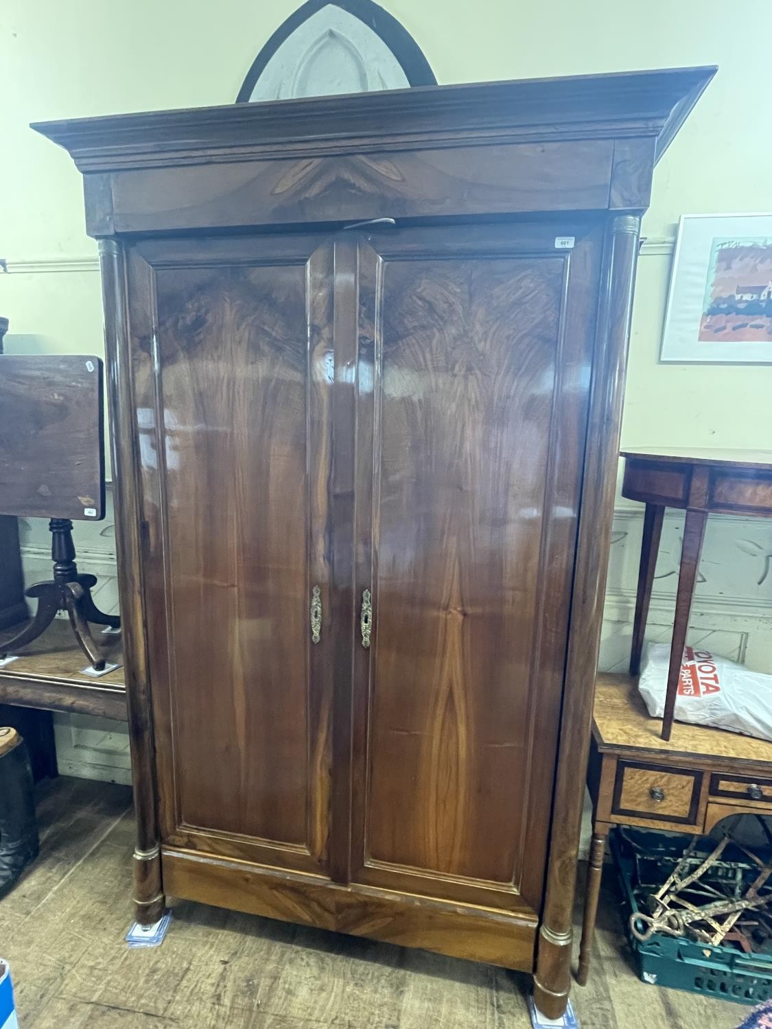 A 19th century French armoire having two cupboard doors, flanked by column supports with gilt