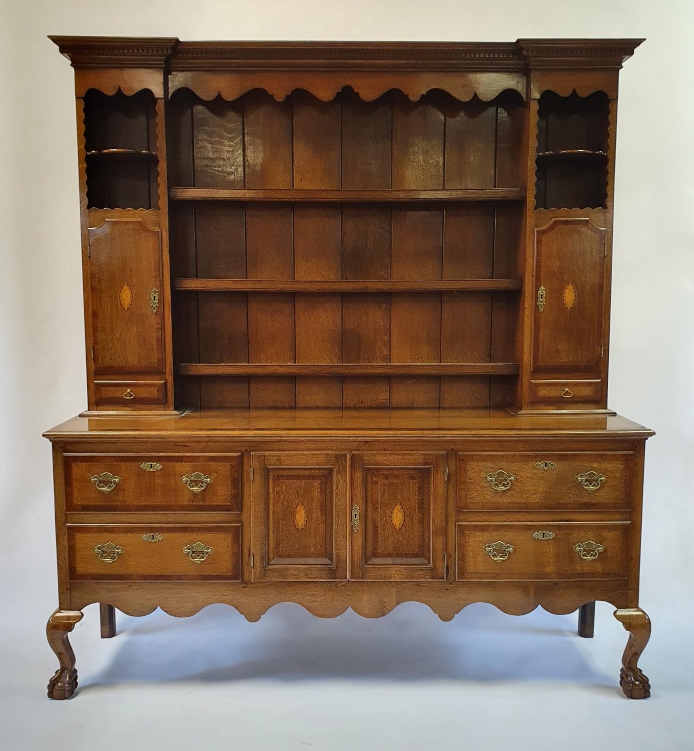An 18th century style oak dresser, the top with shelves, two cupboard doors and two drawers, the