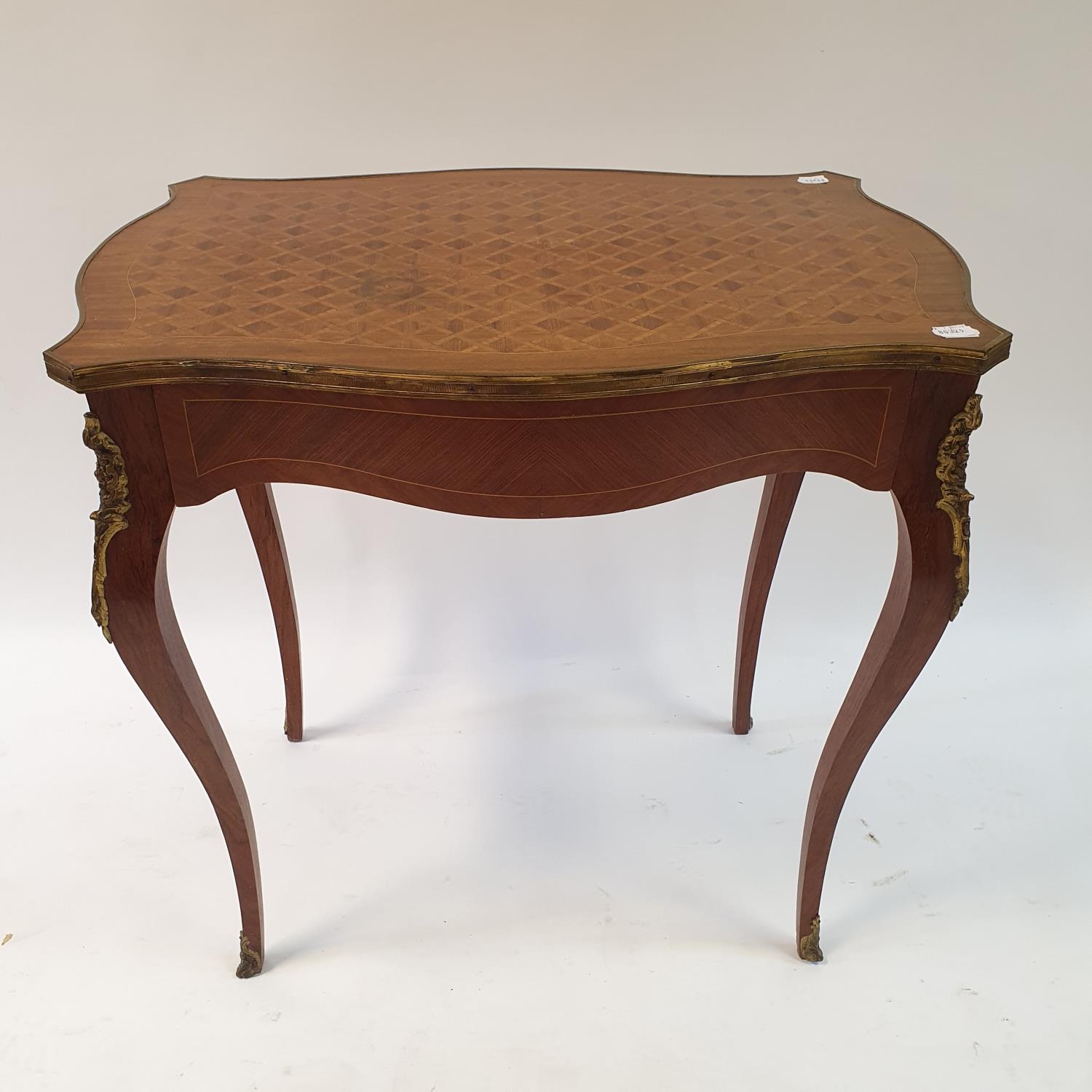 A 20th century French rosewood serpentine side table with parquetry inlay, having a single frieze