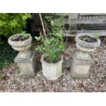 A pair of composite stone garden planters, with reeded bodies, 38 cm diameter, on rectangular