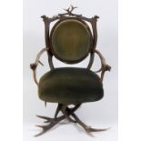 A mid-19th entury antler grotto type armchair, with composition dog heads to the arms and top rail