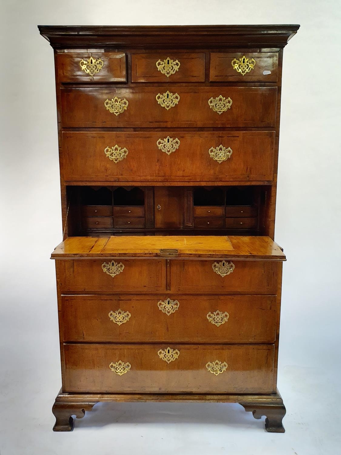 A walnut secretaire chest on chest, crossbanded and with herringbone inlay, the top having three