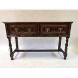 An 18th century style oak dresser base, having two drawers, on turned legs, united by a stretcher,