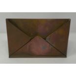 A brass letter stand, in the form of an envelope, engraved Harrods, 23 cm wide Water damaged