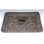 An Indian silver coloured metal rectangular tray, decorated storks and birds with a central blank